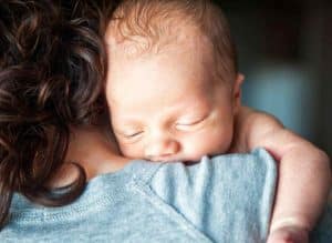 Wochenbett - Mutter mit Baby an der Schulter