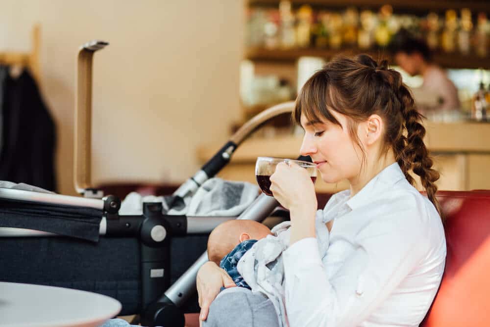 Stillen in der Öffentlichkeit Mutter sitzt stillend in einem Café