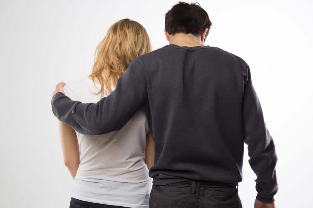 Fehlgeburt - Mann mit Frau im Arm von hinten