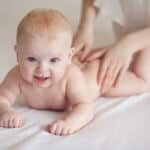 Babymassage: Baby wird am Rücken massiert