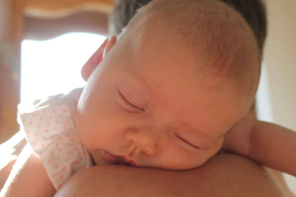 Babyschlaf Baby schläft an der Schulter der Mutter