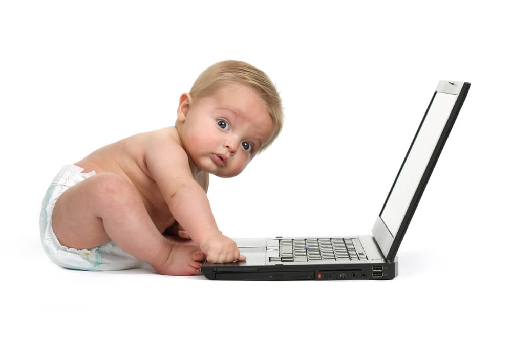 Schreien lassen - Baby sitzt vor einem Laptop