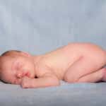 Windelfrei Nacktes Baby auf einem weichen Stoff liegend