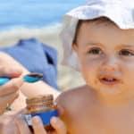 Der erste Urlaub mit dem Baby - Mutter füttert Kleinkind mit einem Brei