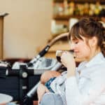 Stillen in der Öffentlichkeit Mutter sitzt stillend in einem Café