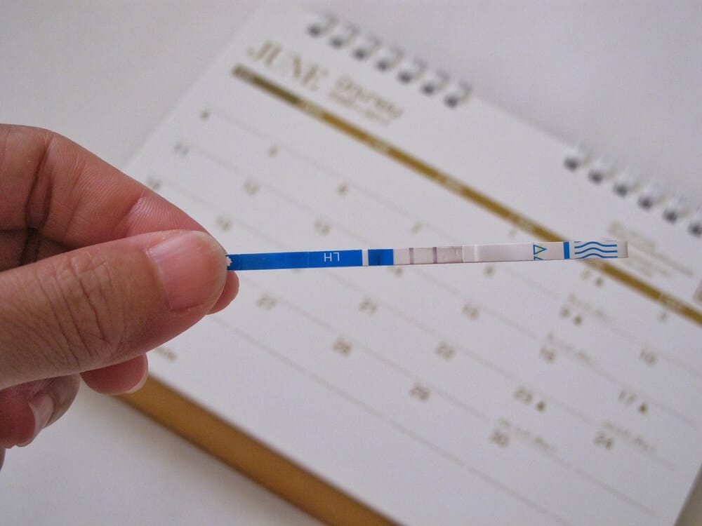 Positiver Schwangerschaftstest über einem Kalender