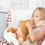 Pseudokrupp Husten - Hustendes Kind mit Kuschelbär im Arm