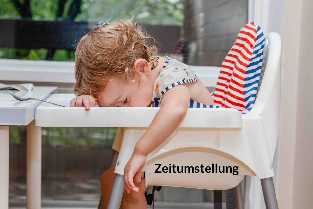 Zeitumstellung Kleinkind sitzt müde vornübergebeugt auf einem Kindersitz