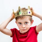 Entthronung - Kleiner Junge hält seine Krone auf dem Kopf fest