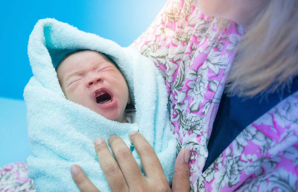Wochenbett - Mutter mit schreiendes Baby im Arm