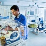 Frühchen - Arzt bei einer Untersuchung eines Frühchens im Brutkasten