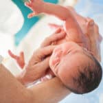 Baby nach der Geburt hochgehalten