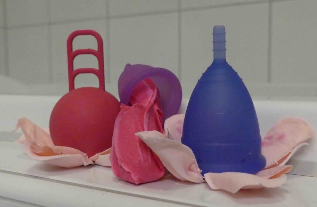 Menstroationstasse - Verschiedene Menstassen mit Rosenblätter dekoriert