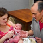 Hausgeburt Vater durchschneidet die Nabelschnur