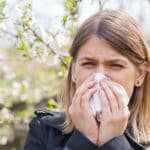 Pollenallergie Frau am Niesen