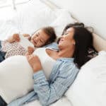 zweite Kind - Schwangere Mutter mit Kind auf dem Bett liegend