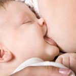 Nuckeln: Baby trinkt genüsslich an Mamas Brust