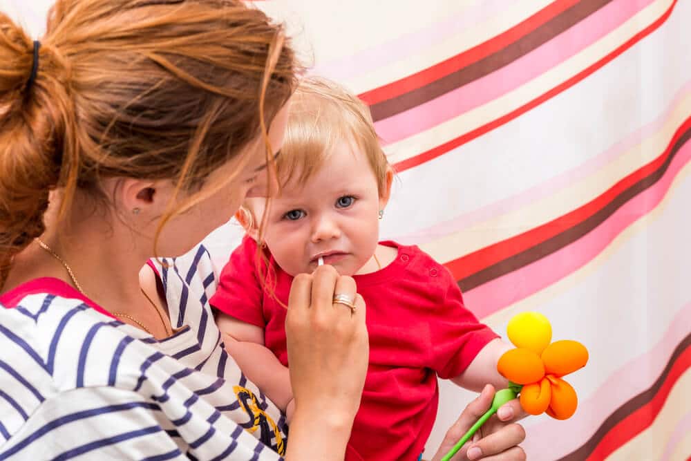 Mutter putzt Kleinkind die Zähne