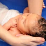 Wassergeburt: Baby wird im Wasser gehalten