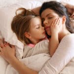 Alleinerziehend - Mutter liegt mit Tochter im Bett