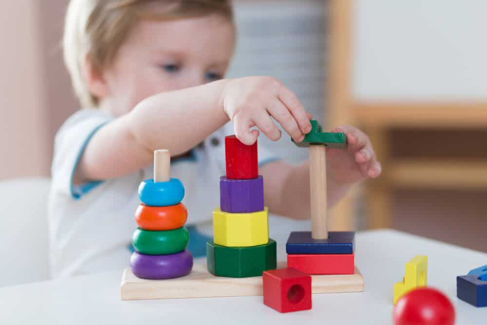 Montessori - Kind spielt mit Holzklötzen