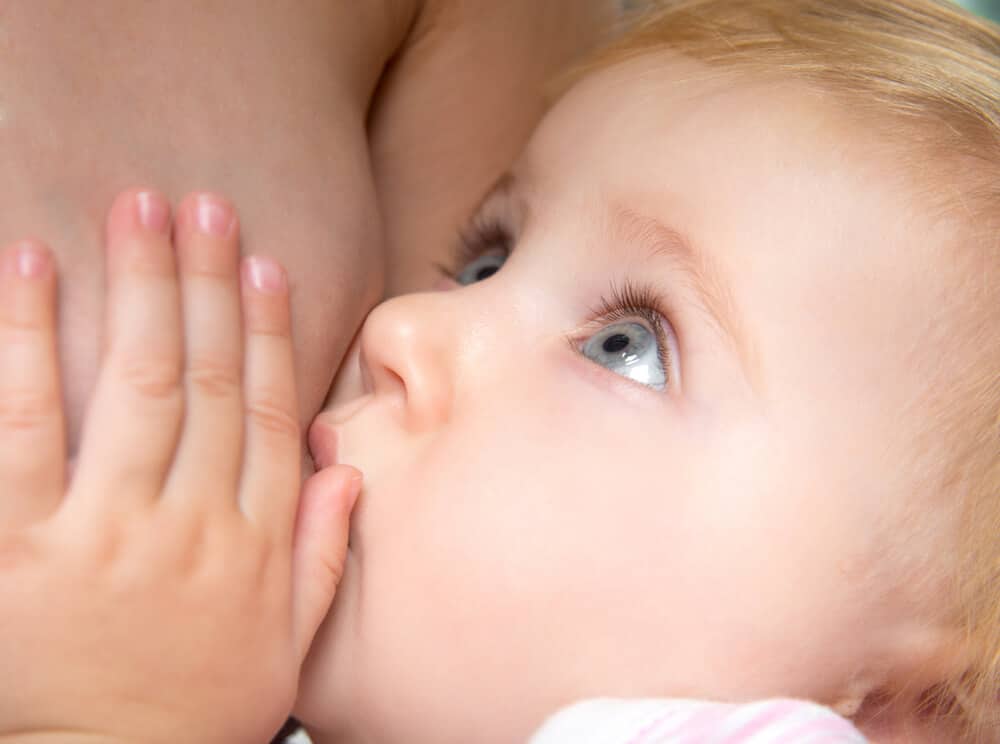 Stillen - ein Baby schaut seine Mutter beim Stillen mit großen Augen an