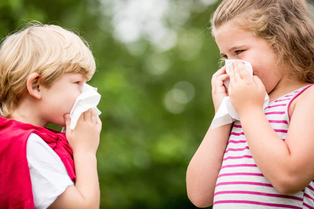 algovir® Erkältungsspray / Nasenspray - Mädchen und Junge putzen sich die Nase