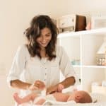 Wickeln Mutter wickelt ihr Kind