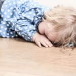 Elternschule - Kind liegt auf dem Boden